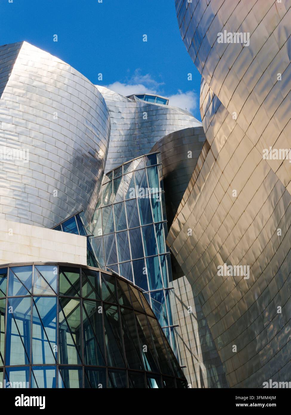 Die geschwungenen Titaniium- und Glasoberflächen des Guggenheim-Museums von Frank O. Gehry in Bilbao, eine gekürzte Ansicht, die den Rahmen mit blauem Himmel darüber füllt. Stockfoto