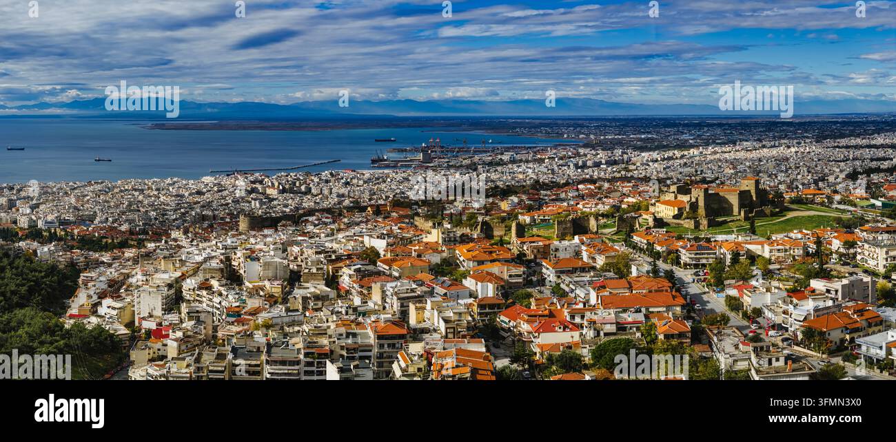 Panoramische Luftansicht von Thessaloniki, die die historische Heptapyrgion-Festung, die dichte städtische Landschaft und den Thermaischen Golf unter dramatischem Licht zeigt Stockfoto