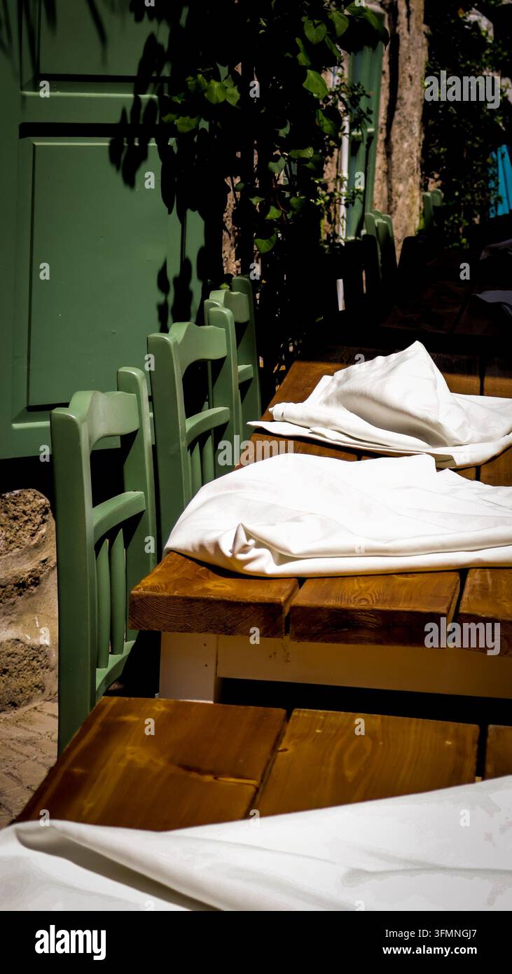 rustikale Restauranttische mit grünen Stühlen Stockfoto