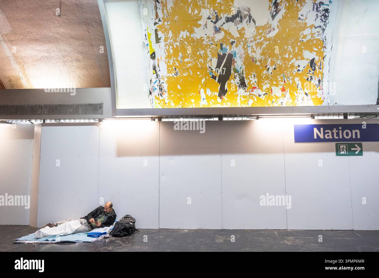 Frankreich. Paris. Nationalstation der RER-A-Bahnlinie. Obdachloser unter einem zerrissenen Plakat. Stockfoto