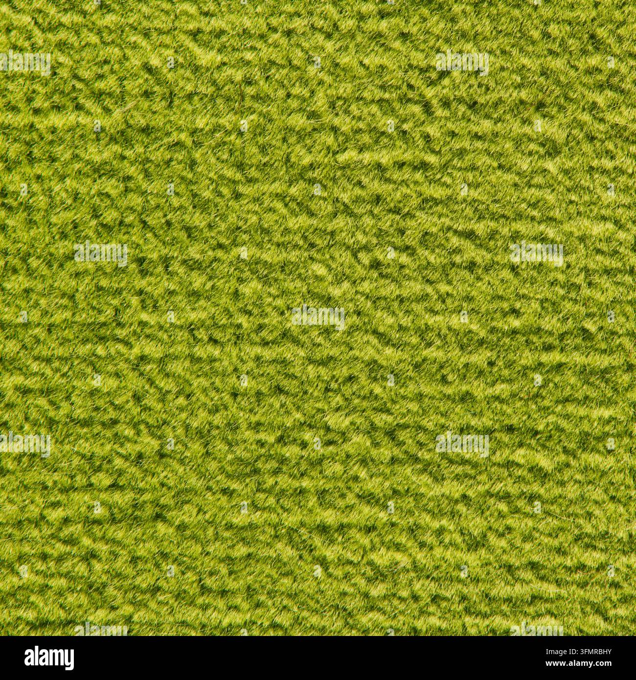 Makrofotografie einer hellgrünen Filzteppichoberfläche, die dichte weiche Fasern und eine subtile diagonale wellige Textur unter gleichmäßiger Beleuchtung zeigt. Stockfoto