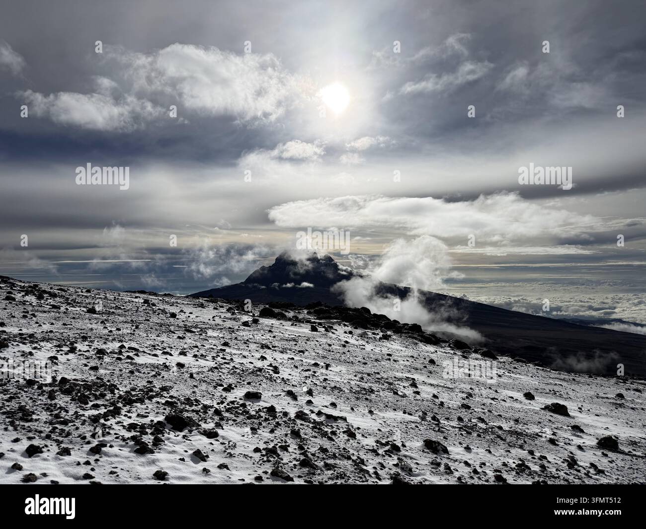 Schichtwolken ziehen über den Mawenzi-Gipfel und eine schneebedeckte Vulkanhochebene hoch auf dem Mount Kilimanjaro, Tansania. - Smartphone-aufgenommenes Stockfoto