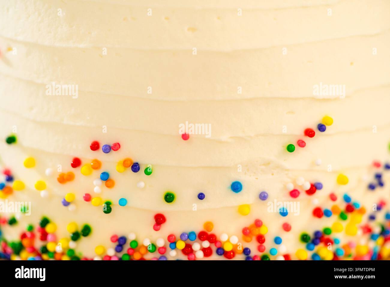 Nahaufnahme von gespritztem Kuchen Zuckerguss mit farbigem Zucker Stockfoto