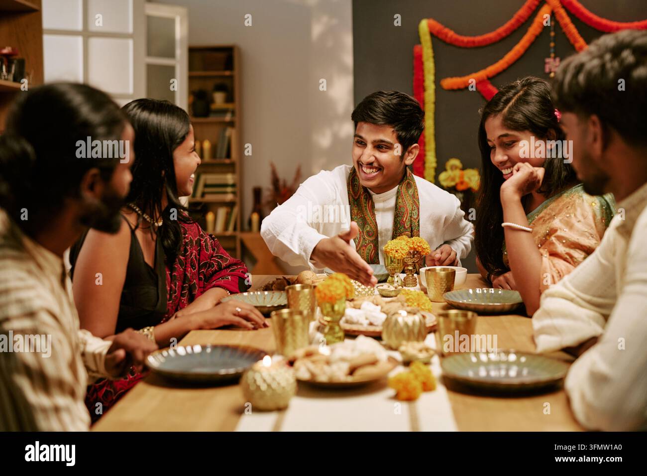 Fröhliche indische Freunde feiern das Lichterfest beim Abendessen Stockfoto