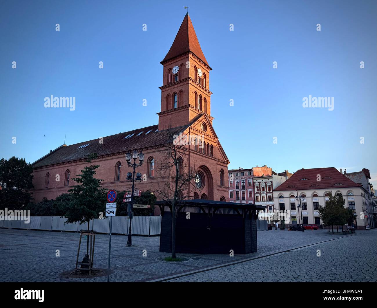 Horizontale Ansicht der ehemaligen evangelischen Heilig-Dreifaltigkeits-Kirche mit ihrem roten Backsteinturmturm auf dem Neumarkt in Thorn, Polen. - Smartphone-aufgenommenes Stockfoto