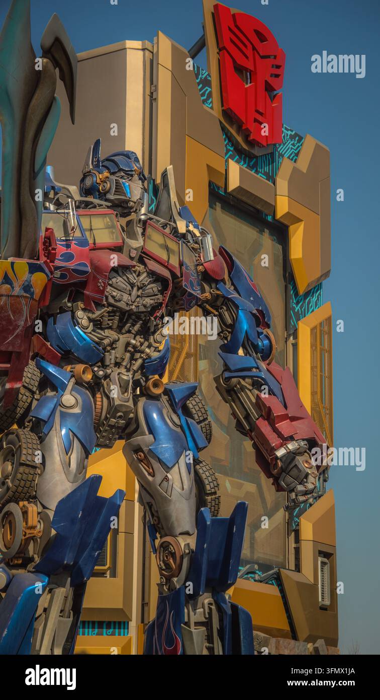 Ansicht der Optimus-Prime-Statue, die vor einem Transformers-Themengebäude mit dem Autobot-Logo im Universal Studios Beijing in Peking steht, Be Stockfoto