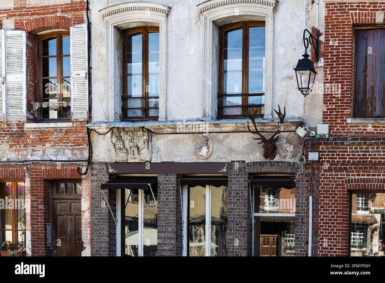 Vintage-Ladenfront mit einer antiken Skulptur und einem ausgestopften Kopf – Lyons-la-Forêt, Normandie Stockfoto