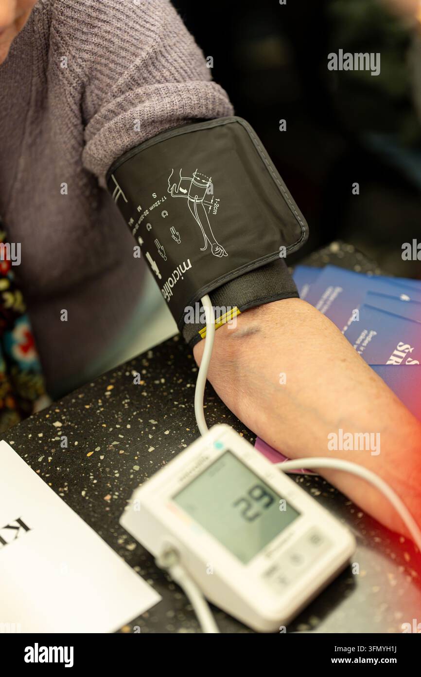 Nahaufnahme einer Blutdruckmanschette am Patientenarm während einer Gesundheitsuntersuchung, medizinisches Messkonzept. Stockfoto