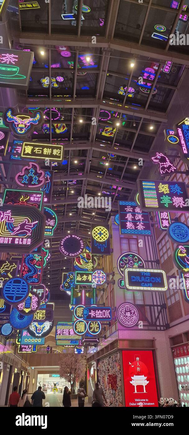 Eine lebendige Nachtszene zeigt eine Sammlung von beleuchteten Neonreklamen und Displays. Die hellen rosa, lila und blauen Lichter erzeugen einen schillernden Ef Stockfoto