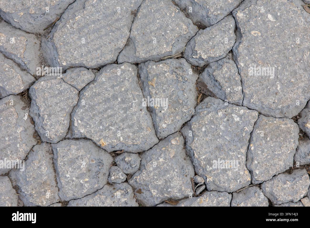 Rissiger grauer Steinpflasterboden – Raue Felsboden-Textur-Hintergrund Stockfoto