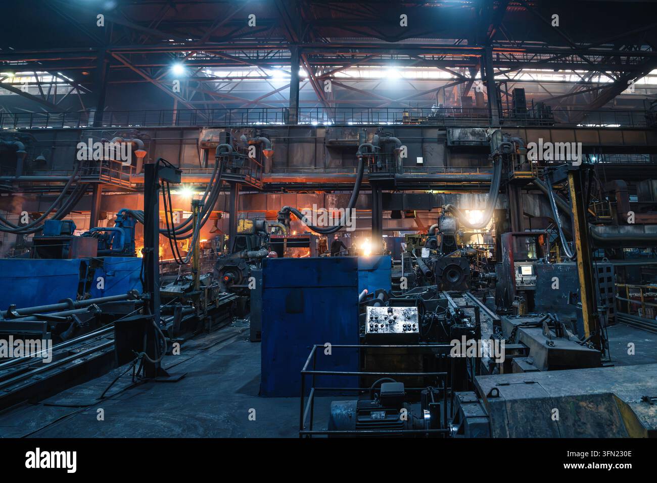 Schwere Industrieanlagen füllen den Produktionsboden einer Stahlfabrik mit automatisierten Geräten für die Fertigung. Stockfoto