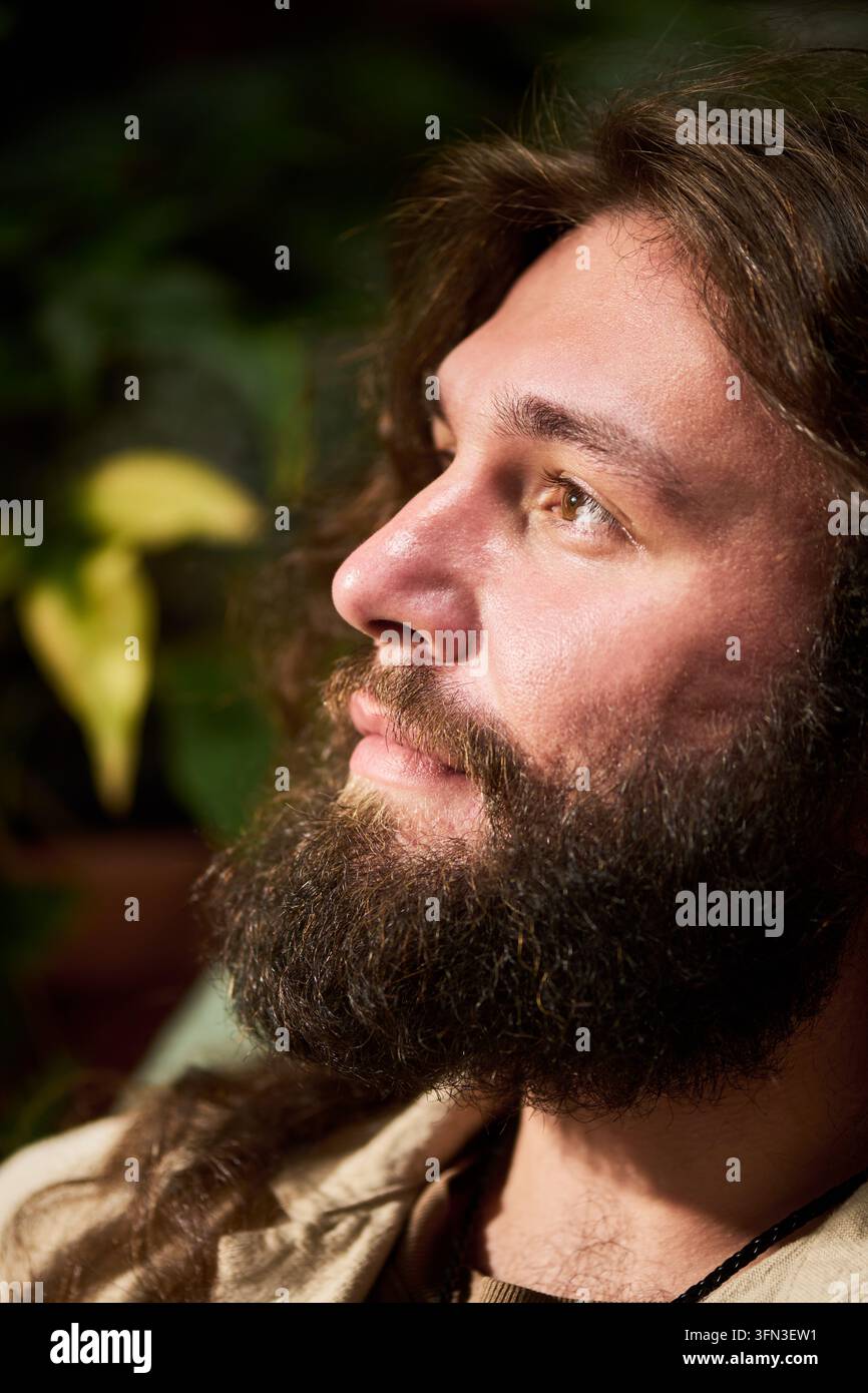 Bärtiger Mann schaut nachdenklich in der Natur weg Stockfoto