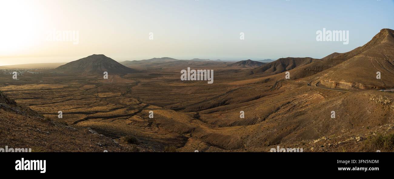 Eine Panoramblick vom Mirador de la Muda zeigt ein weites arides Tal mit der Montana Tindaya, die rechts aufragt, Fuerteventura, Kanarische Inseln, Spanien. Stockfoto