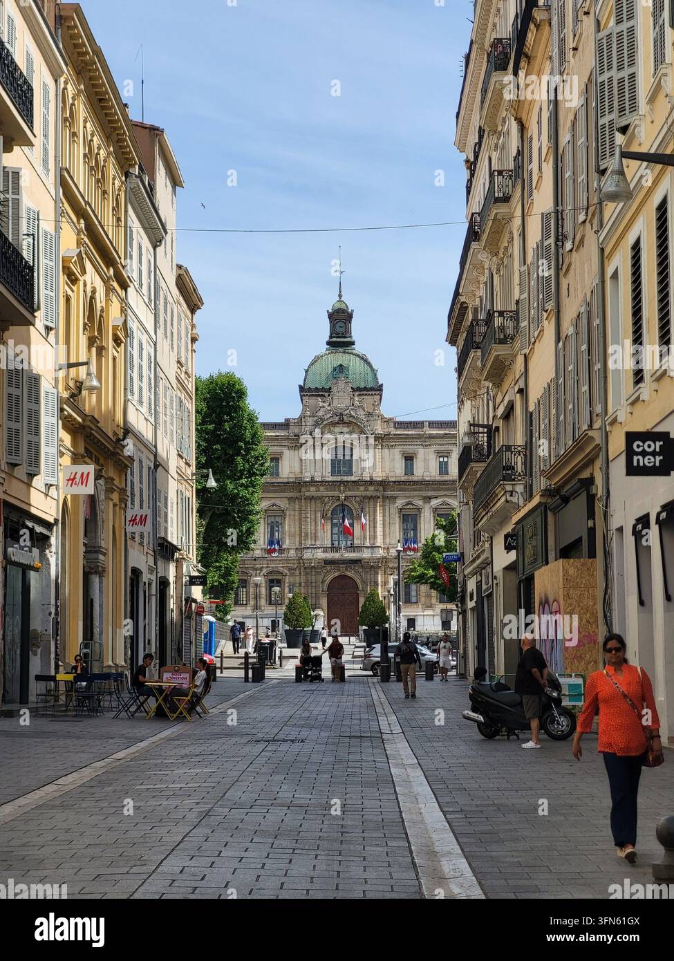Fußgänger und Geschäfte auf einer Straße, die von historischen Gebäuden gesäumt ist, im Zentrum von Marseille, Frankreich. - Smartphone-aufgenommenes Stockfoto