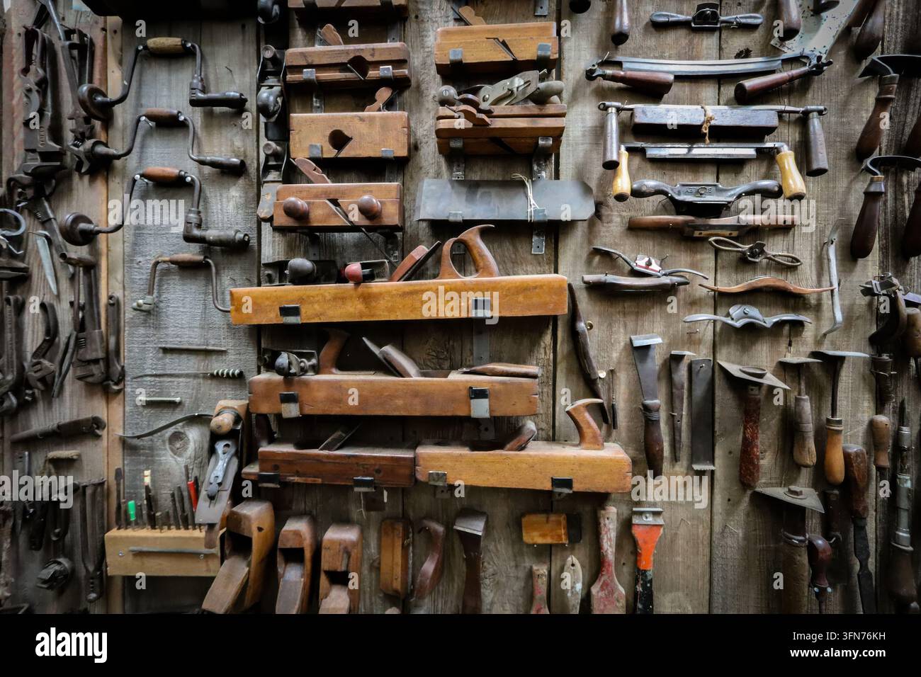 Eine Ausstellung von Vintage-Handwerkzeugen, darunter Hobel, Meißel, Bohrer, Schaber, Schraubenschlüssel und mehr. Stockfoto