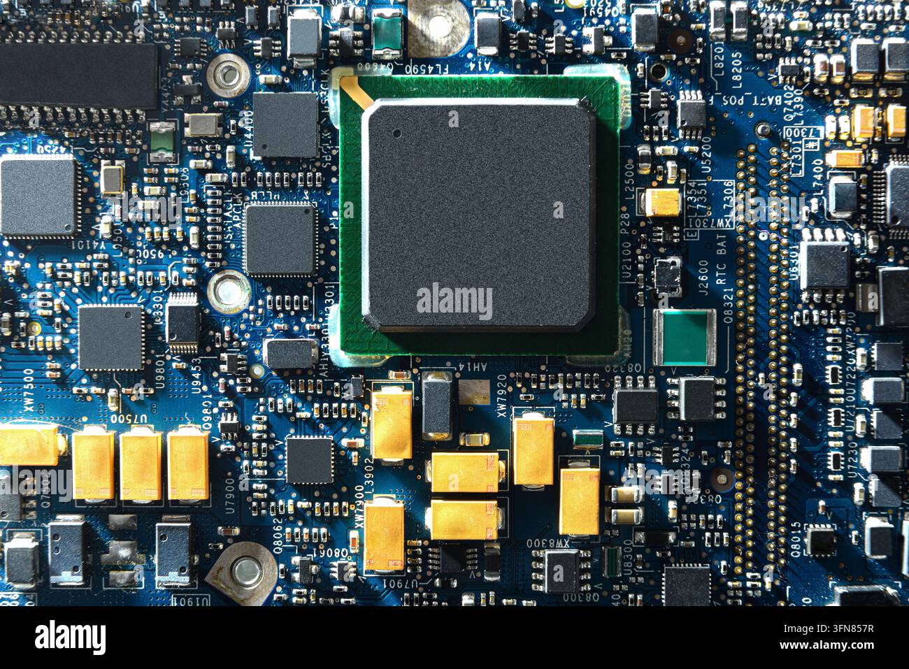 Detaillierte Ansicht von oben einer Hauptplatine mit einem zentralen Prozessorchip, umgeben von Kondensatoren, Widerständen und Steckverbindungen. Konzept fortgeschrittener Computertechnik Stockfoto