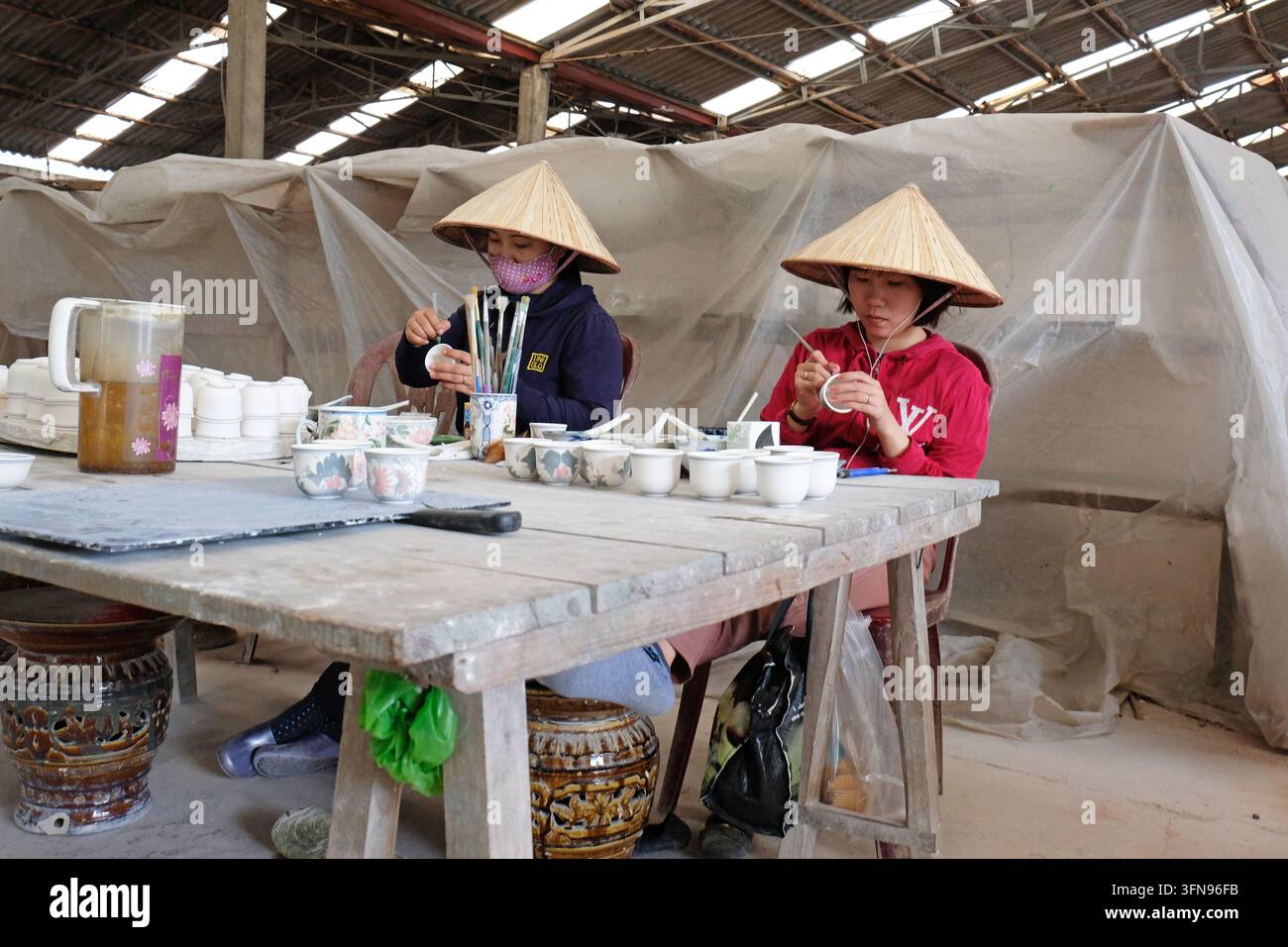 Vietnam - lokale Frauenarbeiterinnen bemalen und dekorieren Geschirr in einer Töpferei Stockfoto