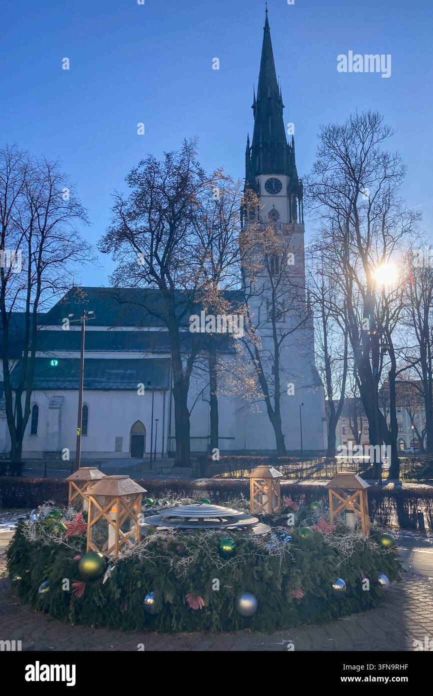SLOWAKEI, SPISSKA NOVA VES - 28. DEZEMBER 2024: Römisch-katholische gotische Kirche der Himmelfahrt der Jungfrau Maria auf dem Rathausplatz - Smartphone-aufgenommenes Stockfoto
