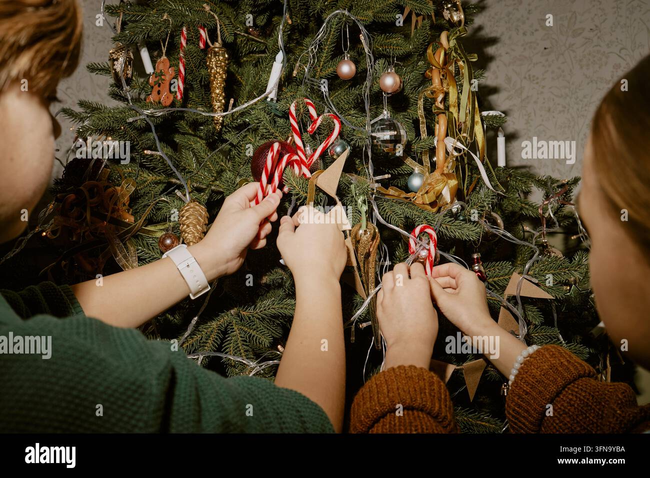 Kinder schmücken den Weihnachtsbaum zu Hause Stockfoto