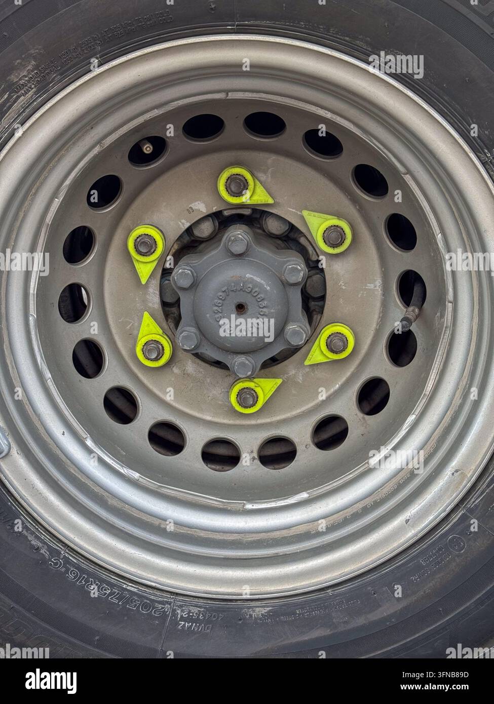 LKW-Rad mit neonfarbenen Indikatoren zur Erkennung von losen Radmuttern Stockfoto