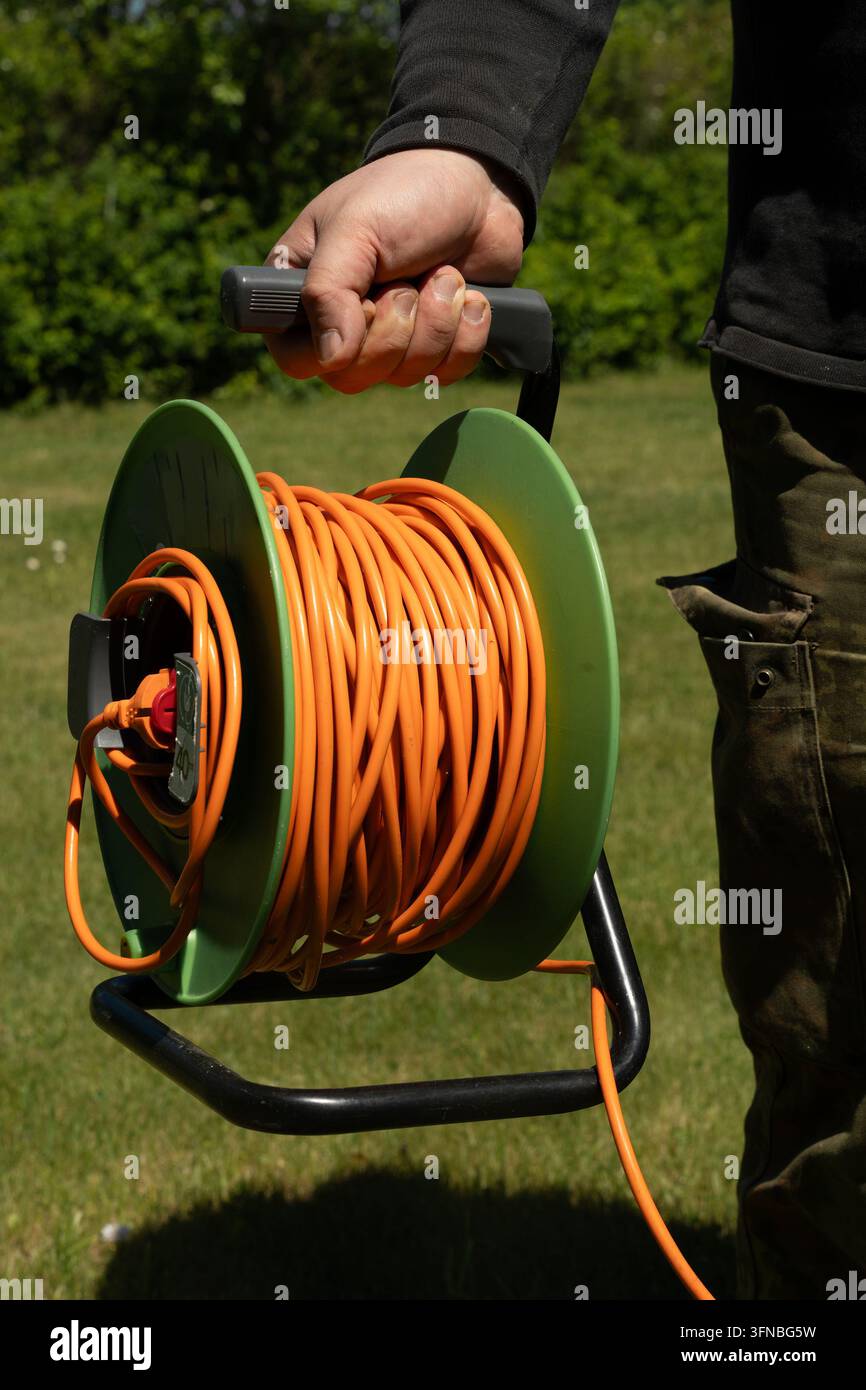 Langes orangefarbenes elektrisches Verlängerungskabel Stockfoto