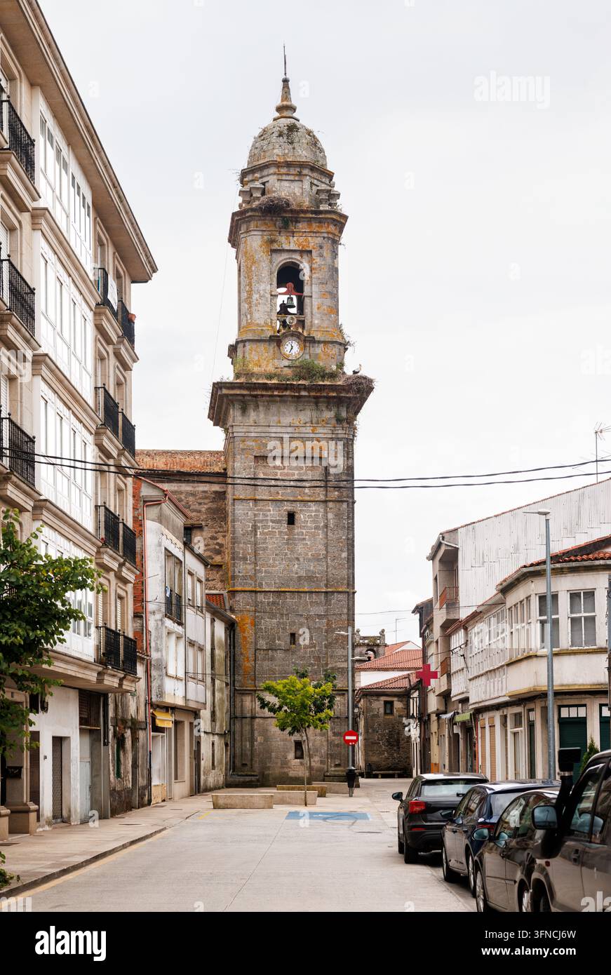 Der historische Glockenturm der Kirche San Pedro, der eine Uhr und Storchennester aufweist, steht auffällig an der Primitivo-Route des Camino de Sant Stockfoto