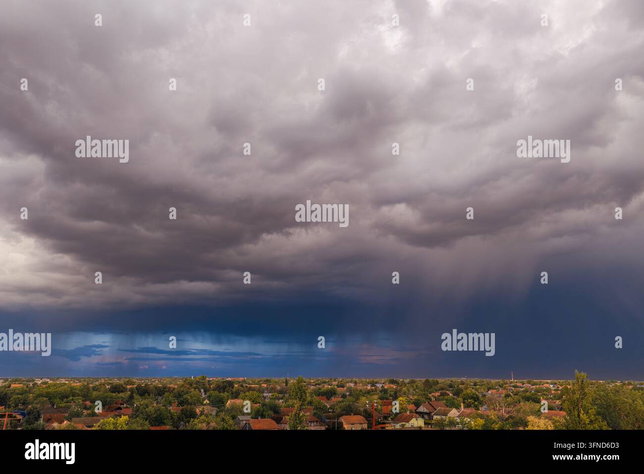 Nahernder Gewittersturm, weitläufige Luftaufnahme eines Wohngebiets unter dramatischen Gewitterwolken über der serbischen Stadt Temerin in der Vojvodina, Serbien. Stockfoto