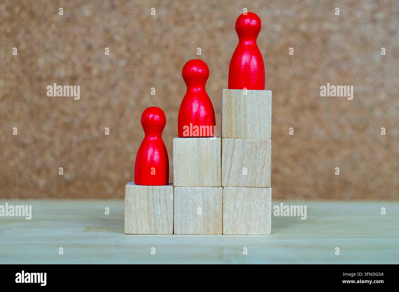 Farbenfrohe Figuren, die in verschiedenen Höhen angeordnet sind und Vielfalt, gleichen Zugang, Inklusion und Führungsmöglichkeiten repräsentieren. Stockfoto