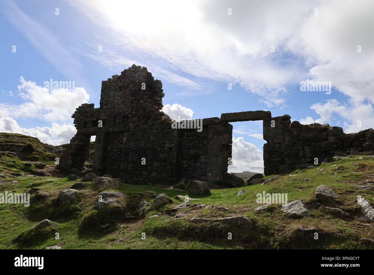 Blick durch eine Fensteröffnung in den ruinierten Granitsteinbruchgebäuden des Foggintor-Steinbruchs im Dartmoor. Stockfoto