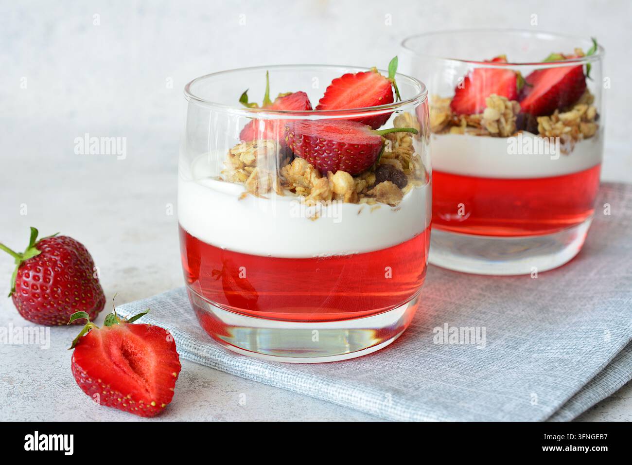Erdbeerdessert mit Gelee, Joghurt und Granola in Gläsern, Frontansicht, Kopierraum Stockfoto