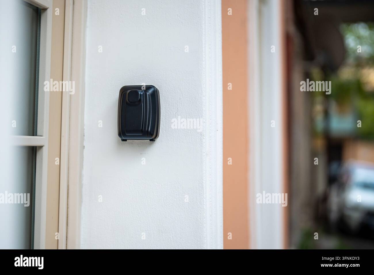 Schwarzer Tresor mit Schlüsselcode im Inneren, der an einer Wand in der Nähe des Eingangstors eines Wohngebäudes angebracht ist. Stockfoto