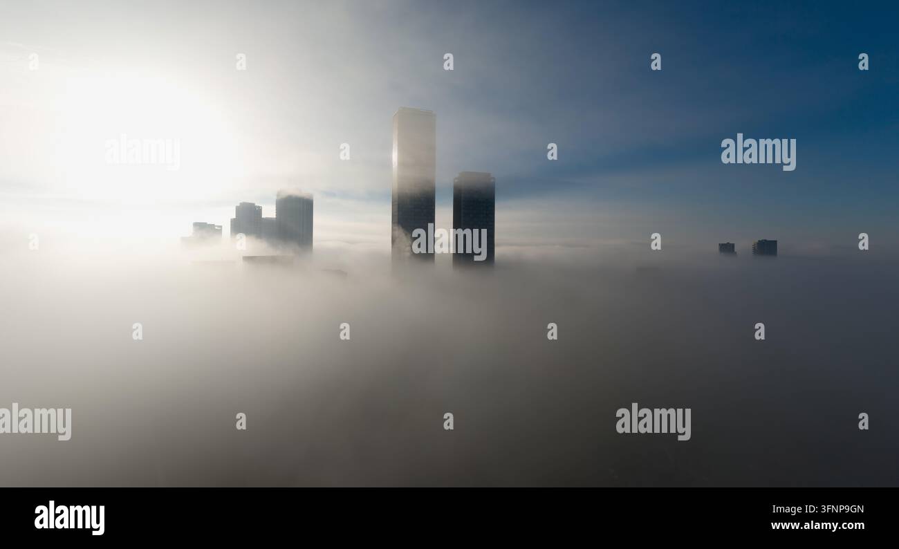 Das Sonnenlicht durchdringt den Morgennebel und enthüllt hohe Wolkenkratzer. Dies wurde in North Acton aufgenommen, mit One West Point im Hintergrund. Stockfoto