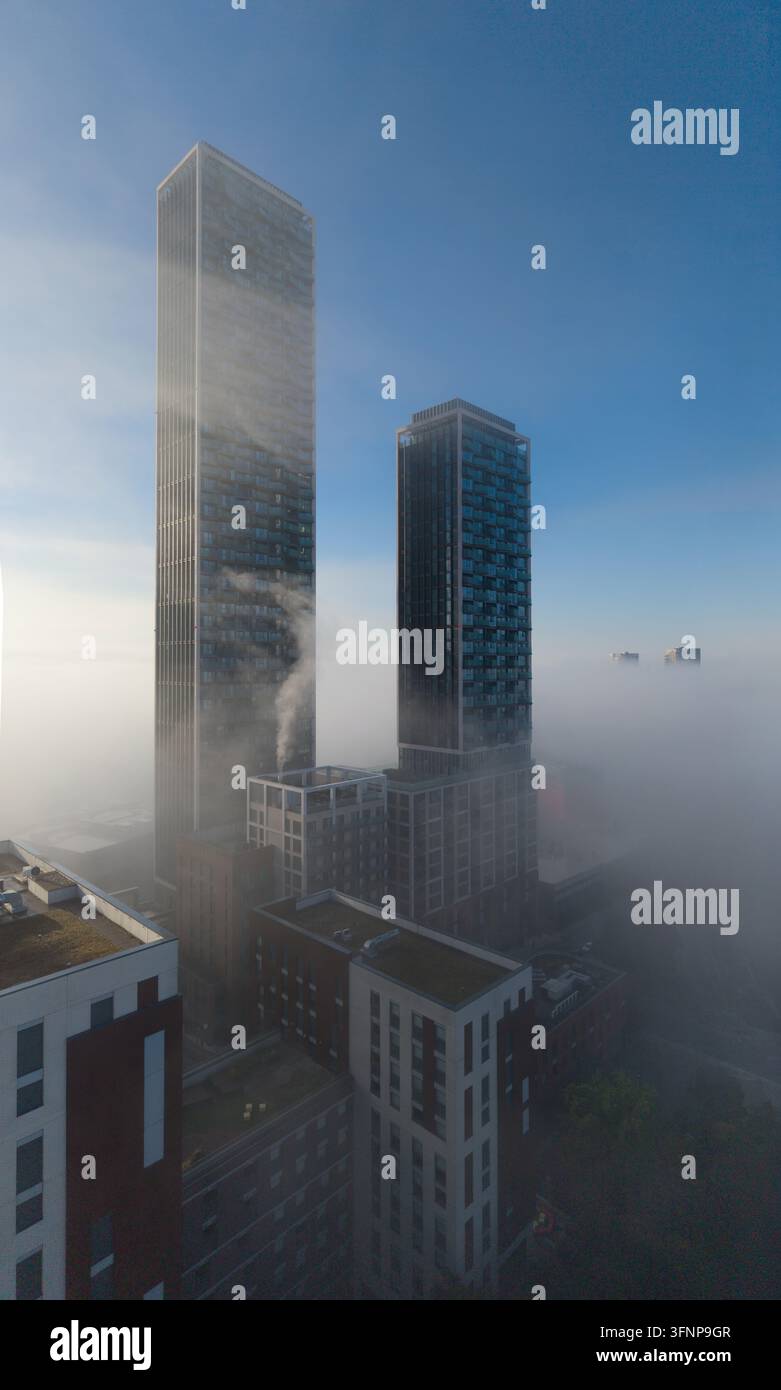 Die Türme von One West Point erheben sich über einem dichten Morgennebel und schaffen eine beeindruckende urbane Wolkenlandschaft. Diese Szene befindet sich in North Acton. Stockfoto