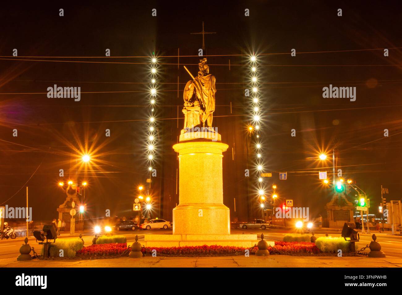 Atmosphärisches Nachtfoto, das das beleuchtete Bronzedenkmal für Alexander Suworow auf dem Marsfeld in Sankt Petersburg einfängt. Die Statue steht auf Stockfoto