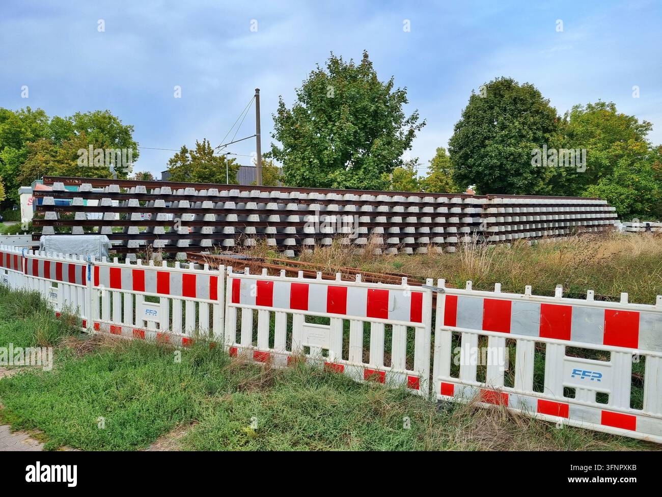 Mainz, Rheinland-Pfalz, Deutschland, September – 28.2026: Gestapelte Straßenbahnschienen und Betonschwellen auf einer Straßenbahnschienenbaustelle. Stockfoto
