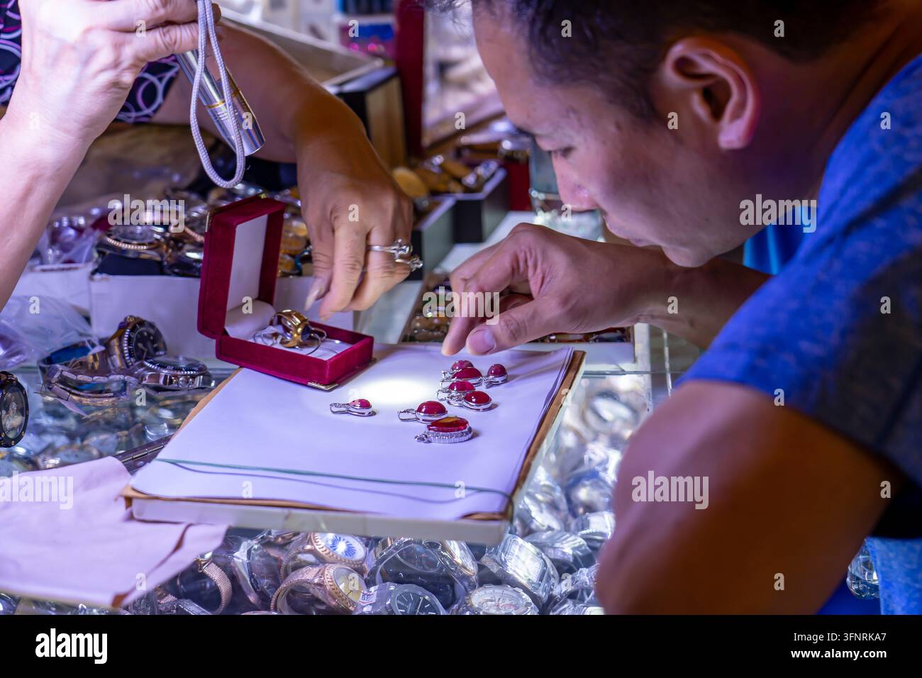 KAMBODSCHA. PHNOM PENH. ZENTRALMARKT. EIN EXPERT SORTNIERT SCHMUCK MIT HALBEDELSTEINEN. Stockfoto
