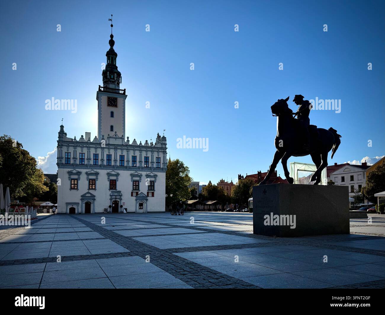 Horizontale Ansicht des Renaissance-Rathauses und des Reiterstandbilds auf dem Hauptmarktplatz des historischen Chełmno, Polen, unter einem klaren blauen Himmel. - Smartphone-aufgenommenes Stockfoto