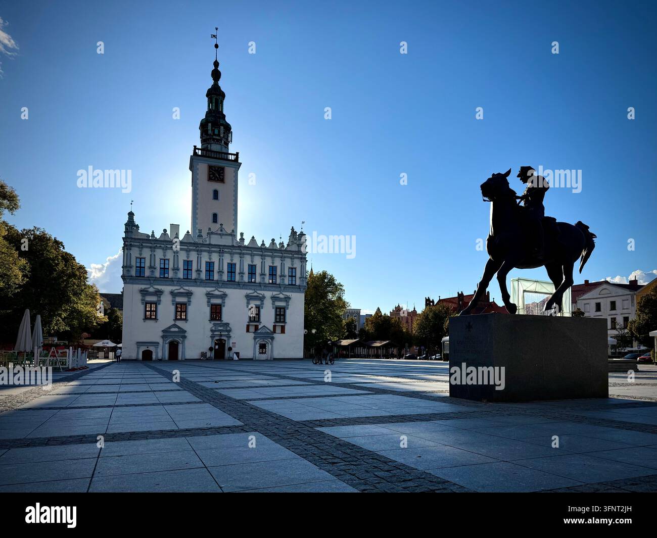 Horizontale Ansicht des Renaissance-Rathauses und des Reiterstandbilds auf dem Hauptmarktplatz des historischen Chełmno, Polen, unter einem klaren blauen Himmel. - Smartphone-aufgenommenes Stockfoto