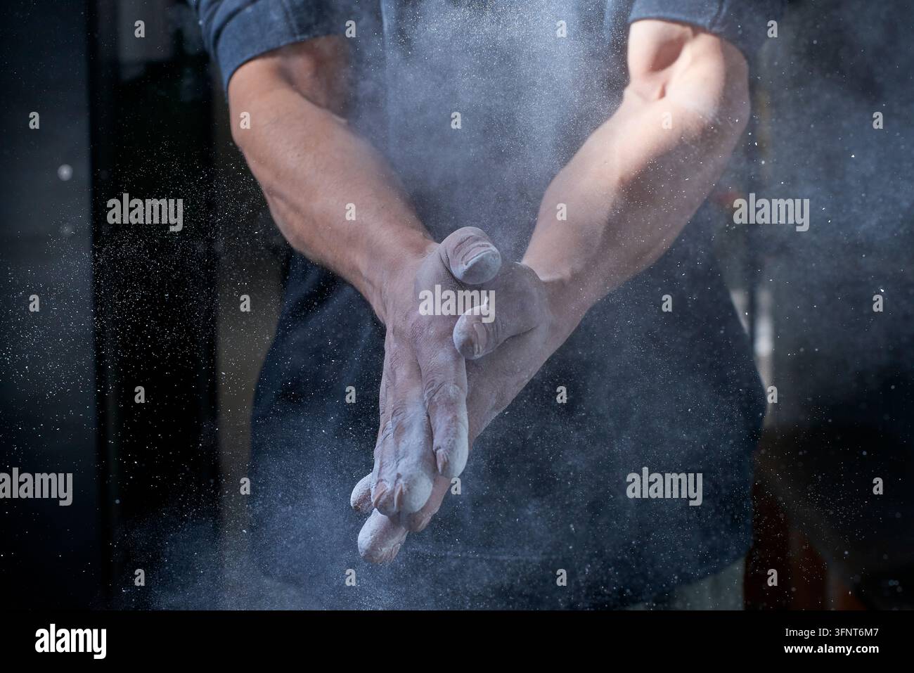 Kletterer klatscht mit den Händen Kreide für mehr Griffigkeit Stockfoto