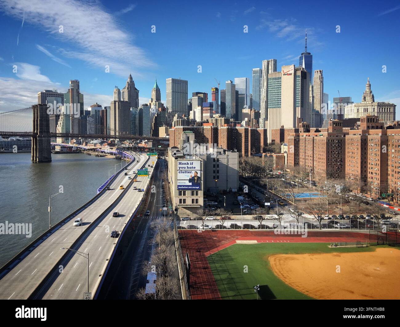 Blick auf New York City mit der Brooklyn Bridge links, die den East River überspannt. Die Skyline zeigt ikonische Wolkenkratzer, darunter One World Trade Stockfoto