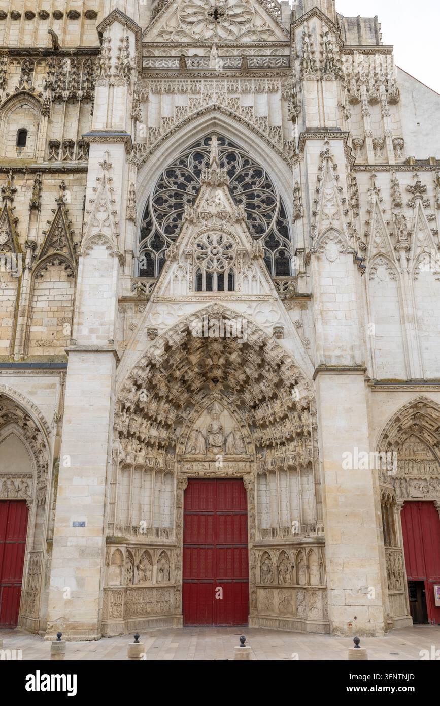 Aufwendige gotische Steinfassade der Kathedrale von Auxerre mit kunstvollen Skulpturen und roten Holztüren Stockfoto