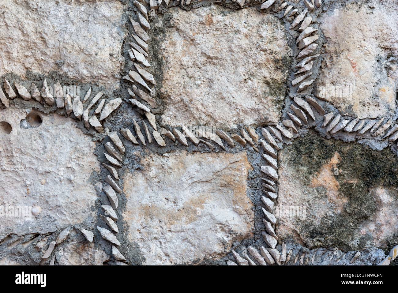 Traditionelle dekorative Steinmauer mit eingebetteten Feuersteinspänen in Mörtel – Handgefertigte mexikanische Mauertextur als Hintergrund Stockfoto