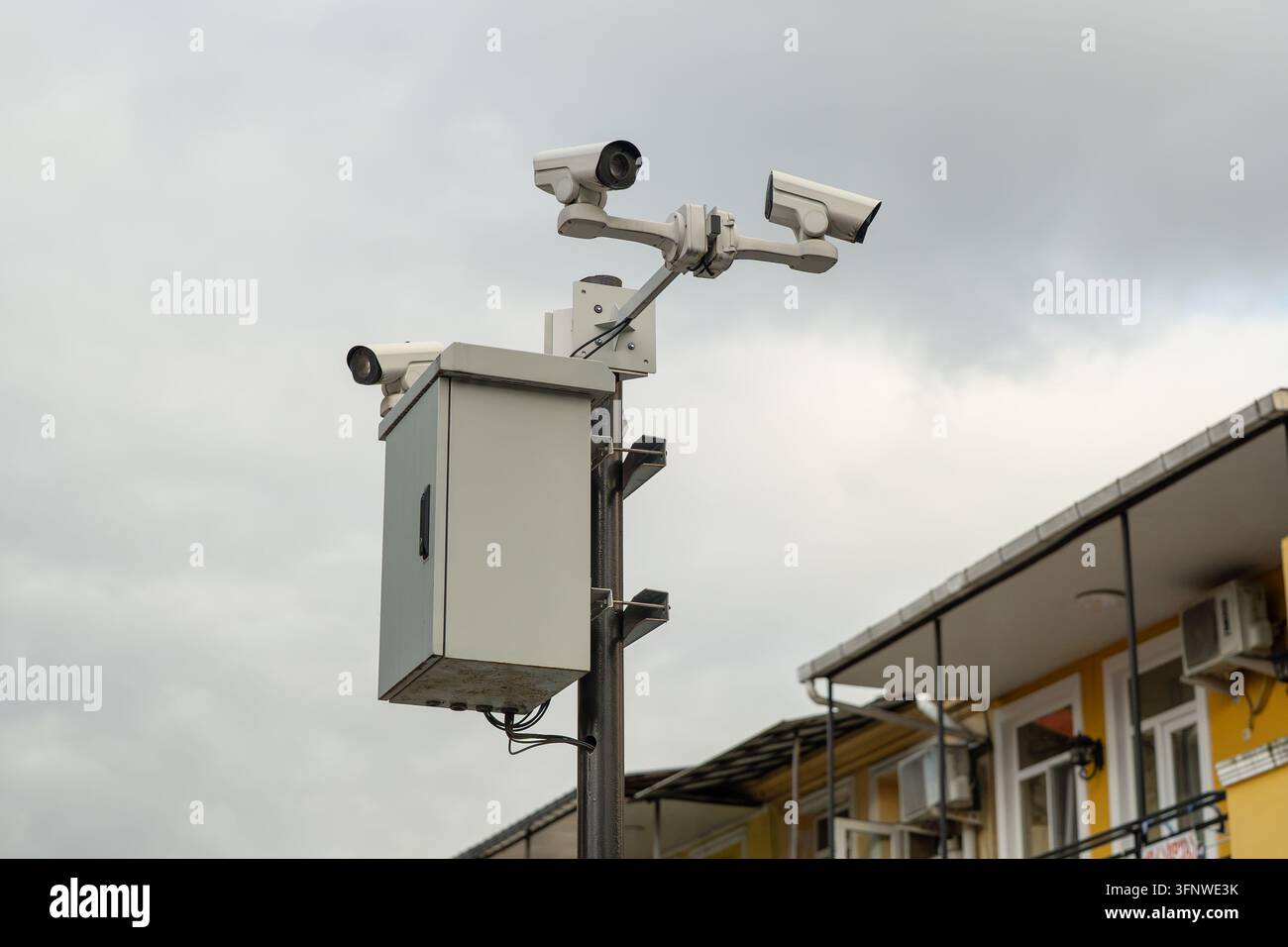 KI-gestützte Videoüberwachungskameras, die auf einem Stadtpfosten für Kontrolle und Sicherheit im öffentlichen Raum montiert sind. Stockfoto
