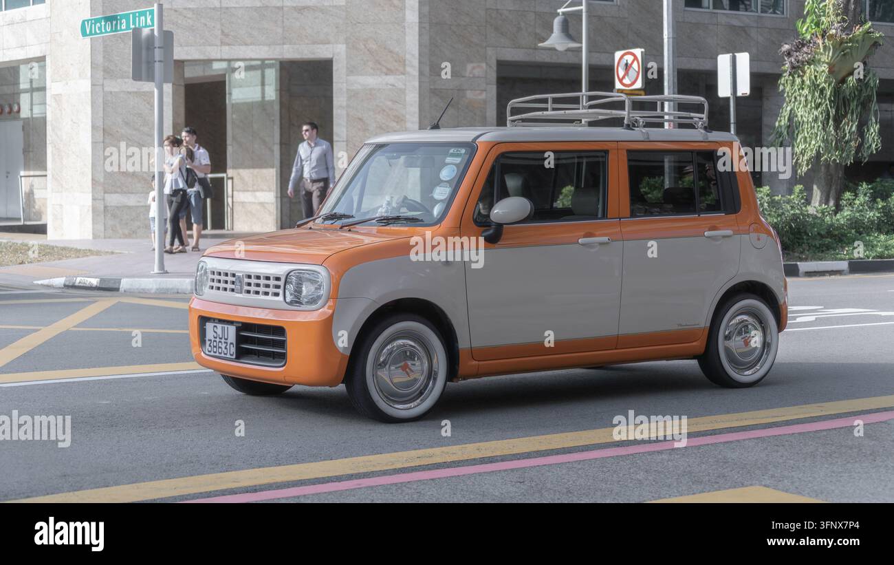 Ein orangefarbener und cremefarbener Suzuki Alto Lapin in der Victoria Street in der Nähe der Victoria Link in Bugis, Singapur. Stockfoto
