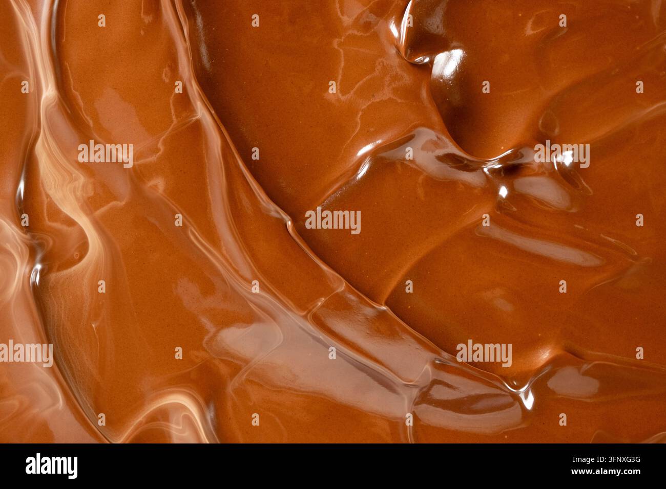 Glänzende geschmolzene Schokoladenwellen abstrakter Hintergrund vertikale Makroaufnahme Stockfoto