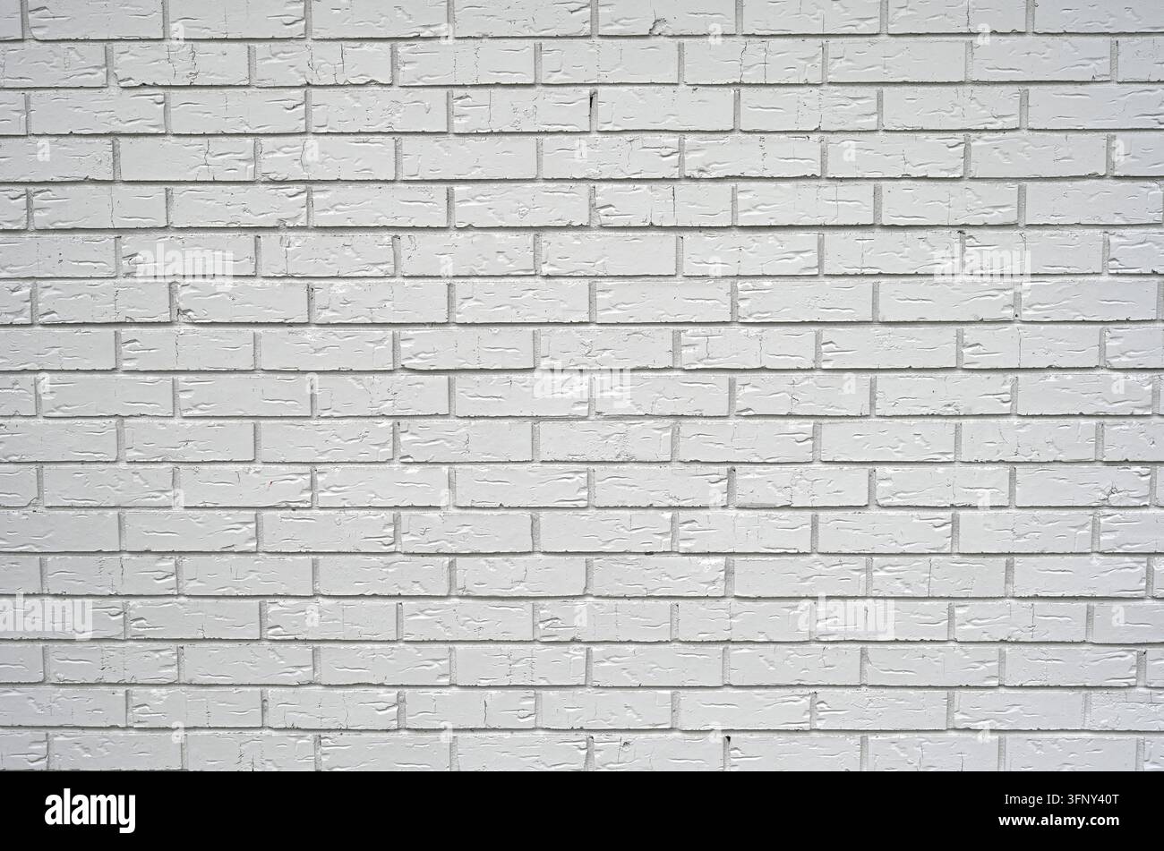 Weiß gestrichene Tonziegel mit glatten, gerillten Oberflächen, angeordnet in einem standardmäßigen versetzten Steinmuster, mit vertieften rauen Mörtelnahtstellen Stockfoto
