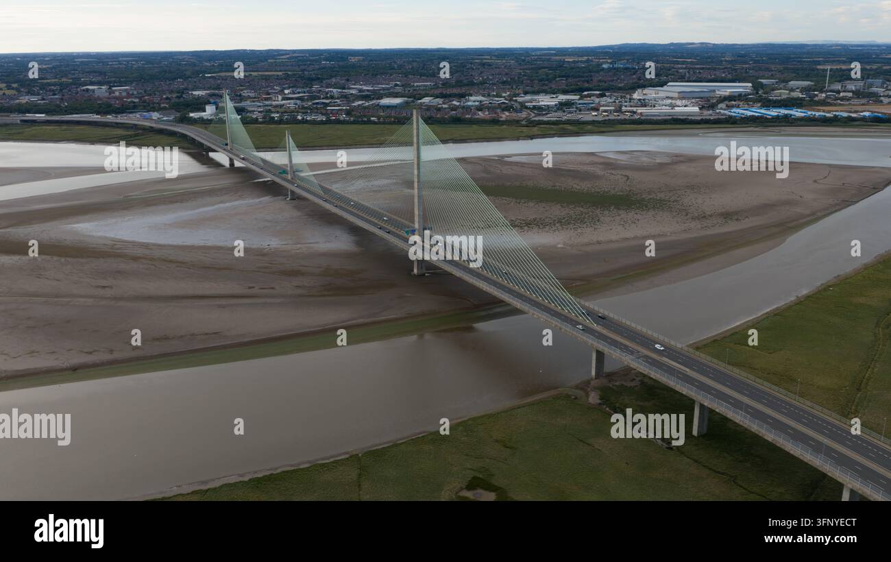 Luftaufnahme der Mersey Gateway Bridge, die den Fluss Mersey überspannt, mit Schlickflächen und grünem Marschland im Vordergrund in Runcorn, England, Vereinigtes Königreich Stockfoto