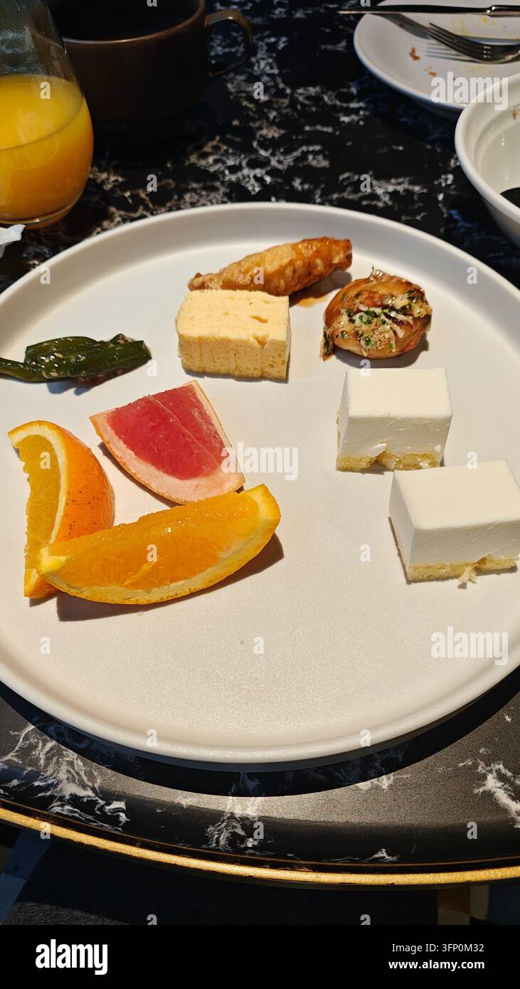 Zitrusfrüchte und Mini-Käsekuchen als Dessert arrangiert Stockfoto