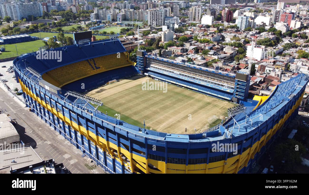 Luftbild des Stadions La Bombonera mit seinen ikonischen blauen und gelben Tribünen und dem grünen Spielfeld, umgeben von der dichten urbanen Landschaft von Buenos Aires Stockfoto