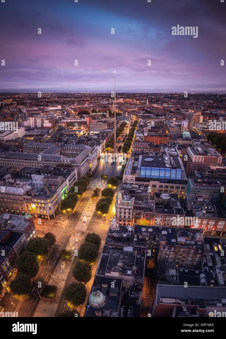 Luftbild des Spires von Dublin, der in der Dämmerung beleuchtet ist und über den historischen Stadtstraßen, Dächern und der urbanen Landschaft von Dublin, County Du aufragt Stockfoto